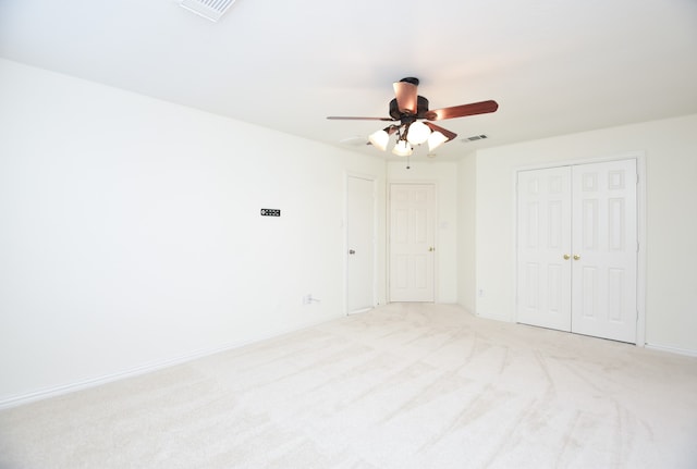 spare room featuring light colored carpet and ceiling fan