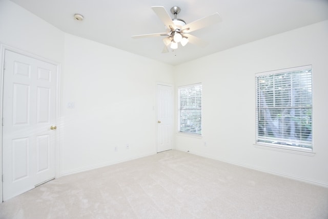 carpeted spare room with ceiling fan