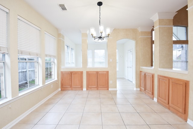 unfurnished dining area with an inviting chandelier, crown molding, and light tile patterned floors