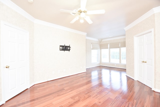 empty room with ceiling fan, crown molding, and hardwood / wood-style floors