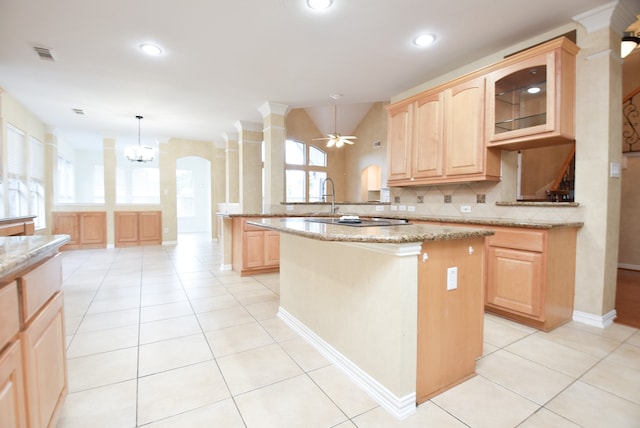 kitchen featuring a kitchen island, light stone counters, kitchen peninsula, and a healthy amount of sunlight