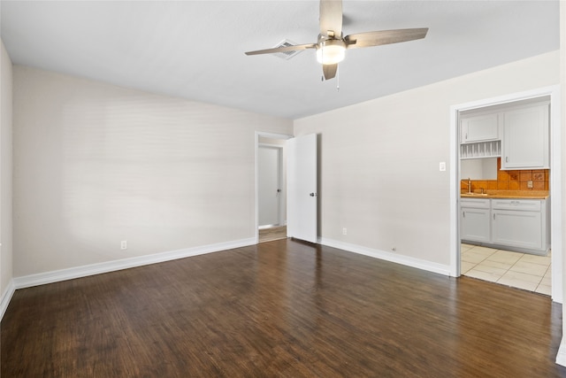 unfurnished room with ceiling fan, sink, and light wood-type flooring