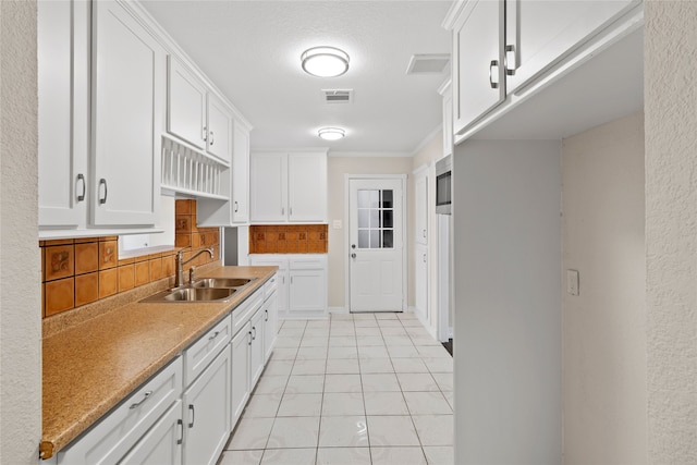 kitchen with sink, decorative backsplash, crown molding, and white cabinetry