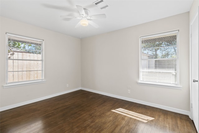 spare room with dark hardwood / wood-style floors, a healthy amount of sunlight, and ceiling fan