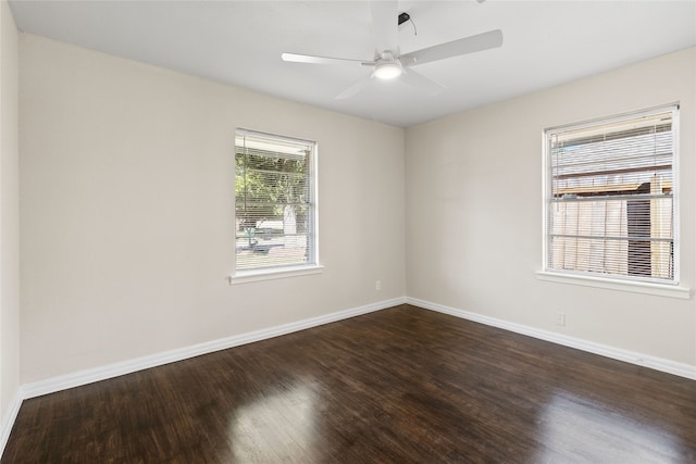 empty room with ceiling fan and dark hardwood / wood-style flooring