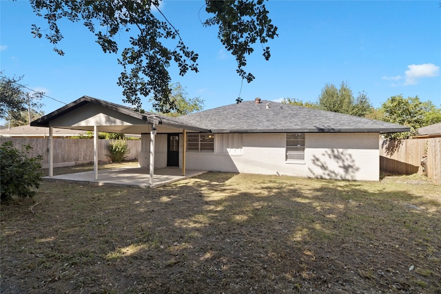 back of house with a patio and a lawn