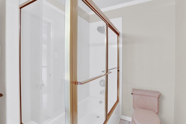 bathroom featuring toilet, ornamental molding, shower / bath combination with glass door, and tile patterned flooring