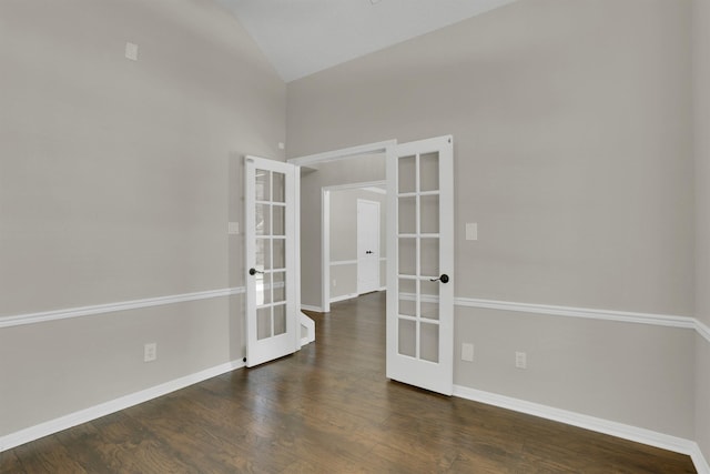 empty room featuring french doors, dark wood-type flooring, and lofted ceiling