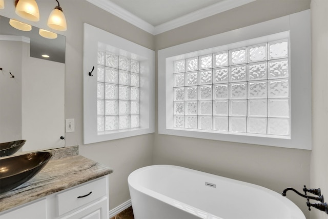 bathroom featuring vanity, ornamental molding, and a bath