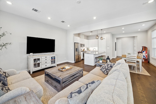 living room with sink and dark wood-type flooring