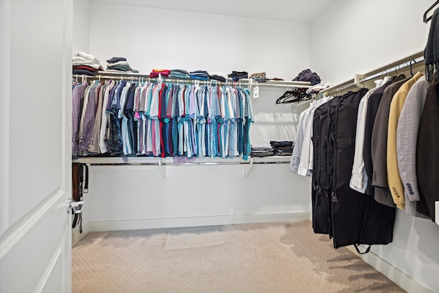 walk in closet featuring light carpet