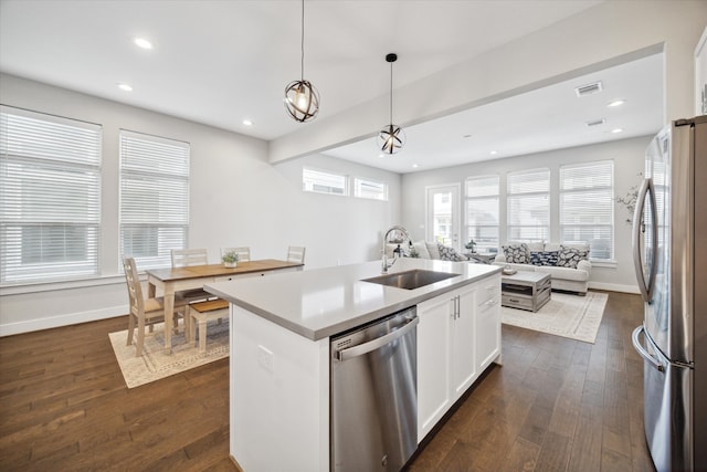 kitchen featuring sink, decorative light fixtures, a center island with sink, white cabinets, and appliances with stainless steel finishes