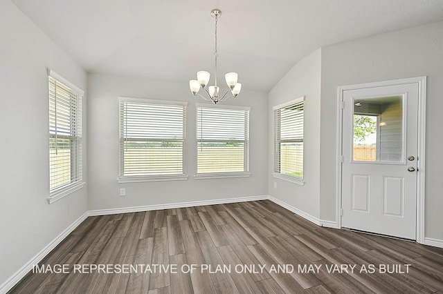 unfurnished dining area featuring lofted ceiling, dark wood-type flooring, and a chandelier