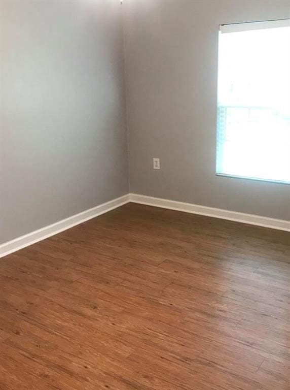 unfurnished room with dark hardwood / wood-style flooring