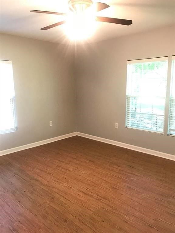 spare room featuring dark wood-type flooring and ceiling fan