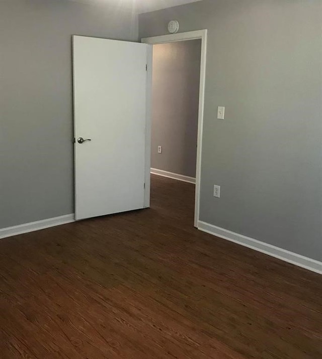 spare room with dark wood-type flooring