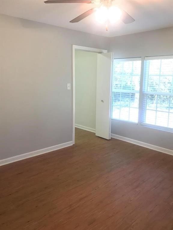 empty room featuring ceiling fan and dark hardwood / wood-style flooring