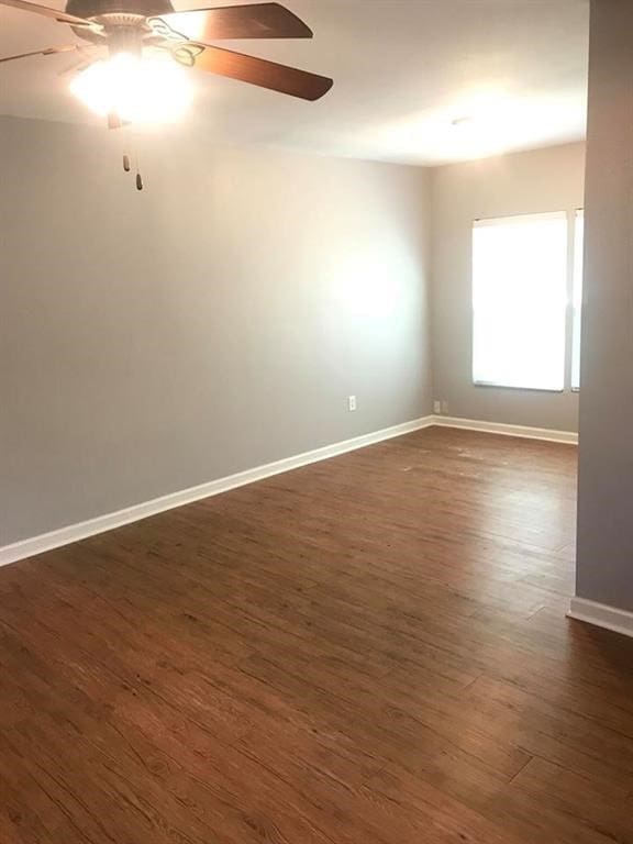 spare room with dark hardwood / wood-style floors and ceiling fan