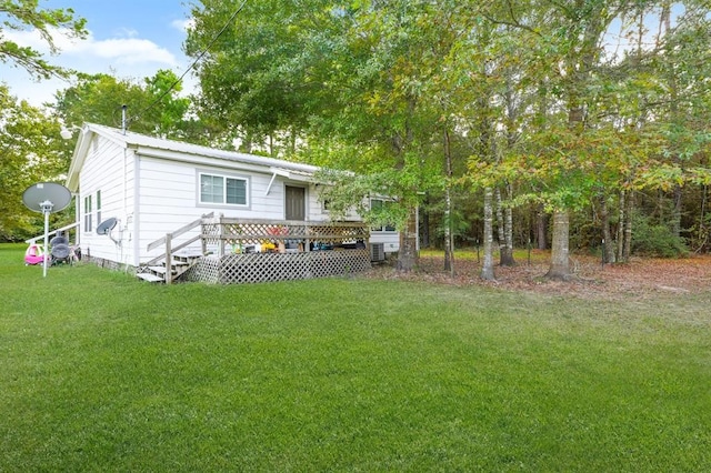 back of house featuring a deck and a lawn