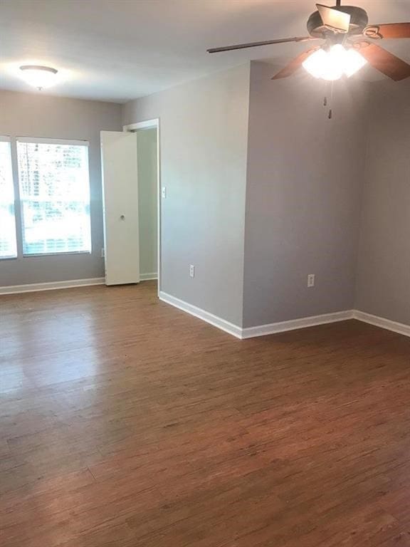 spare room with ceiling fan and dark hardwood / wood-style floors