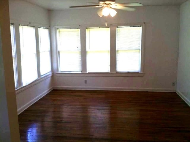 spare room featuring dark hardwood / wood-style floors and ceiling fan