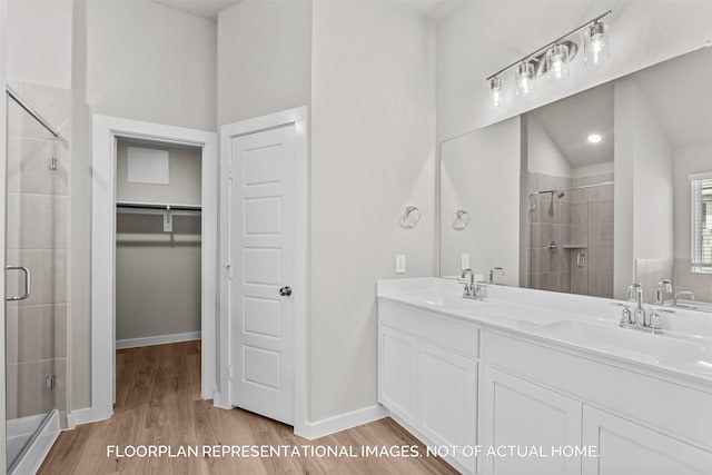 bathroom featuring hardwood / wood-style flooring, walk in shower, and vanity