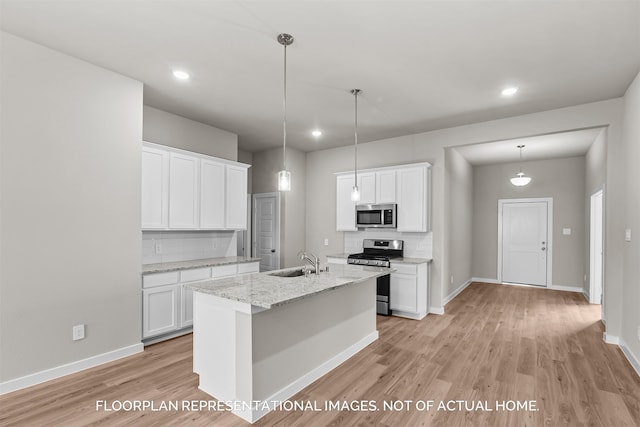 kitchen with decorative backsplash, sink, a kitchen island with sink, appliances with stainless steel finishes, and white cabinets