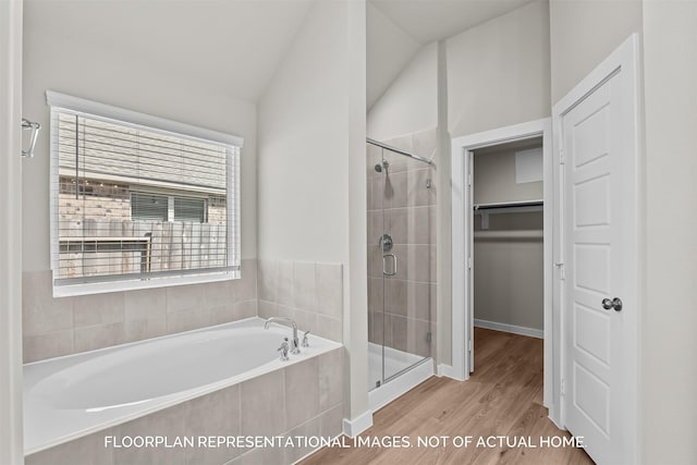 bathroom featuring vaulted ceiling, plenty of natural light, plus walk in shower, and hardwood / wood-style flooring