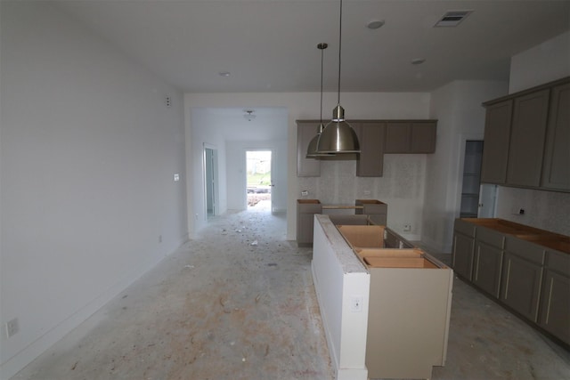 kitchen with gray cabinetry, pendant lighting, and a kitchen island