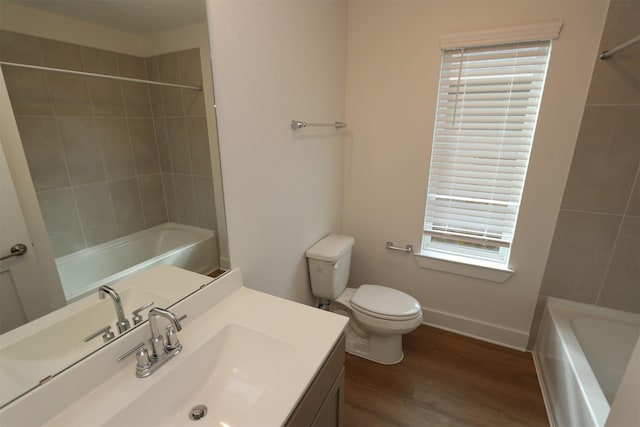 bathroom featuring shower / bath combination, baseboards, toilet, wood finished floors, and vanity