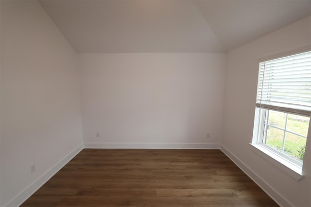 unfurnished room with lofted ceiling, dark wood finished floors, and baseboards