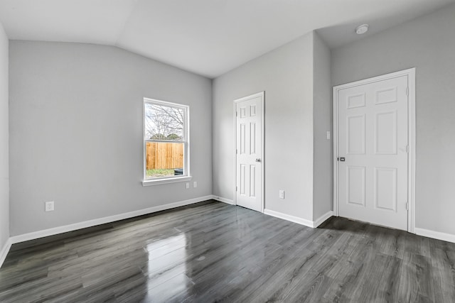 unfurnished bedroom featuring dark hardwood / wood-style floors and vaulted ceiling