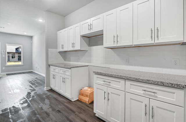 kitchen with decorative backsplash, white cabinets, and dark hardwood / wood-style flooring