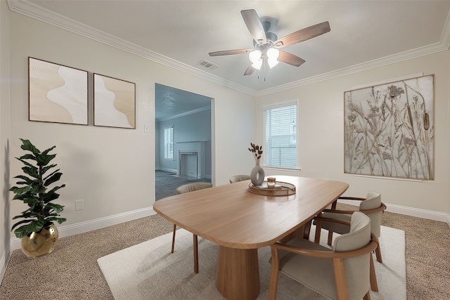 dining space featuring ceiling fan, ornamental molding, and carpet floors