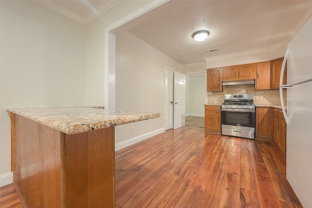 kitchen featuring dark hardwood / wood-style flooring, kitchen peninsula, and stainless steel range with gas stovetop