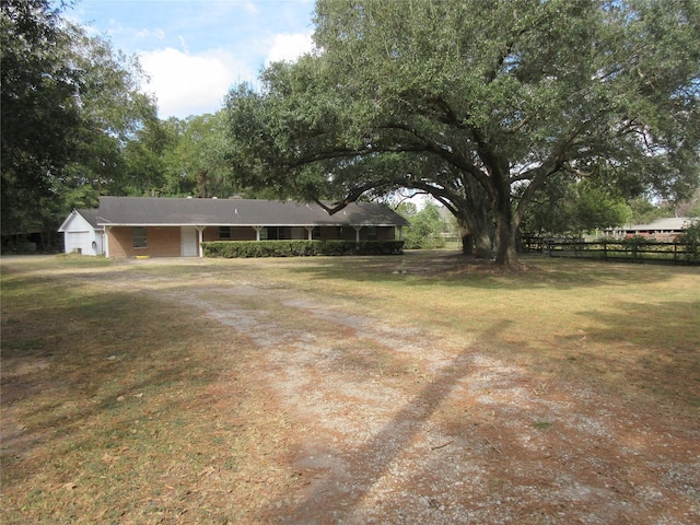 view of yard featuring fence and driveway