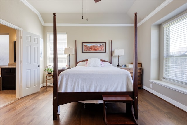 bedroom with ensuite bath, ceiling fan, lofted ceiling, crown molding, and hardwood / wood-style flooring