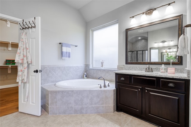 bathroom featuring vanity, lofted ceiling, plus walk in shower, and tile patterned floors