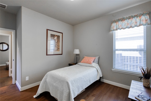 bedroom with dark hardwood / wood-style floors