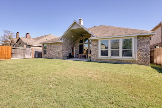 rear view of property featuring a yard, a patio, and ceiling fan