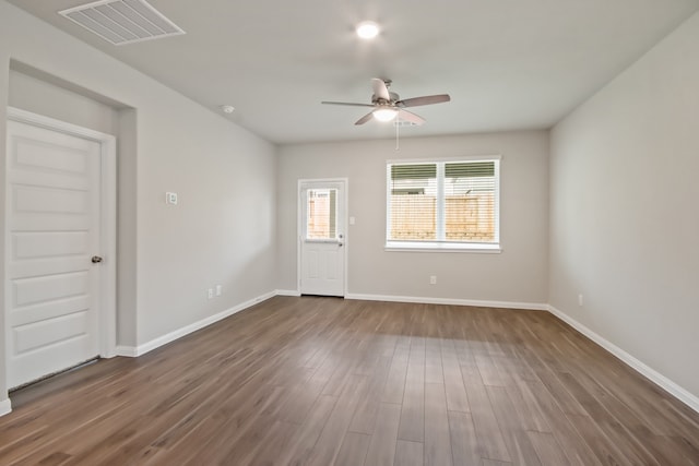 empty room featuring dark wood-type flooring and ceiling fan