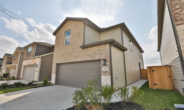 view of front of house featuring stone siding, brick siding, a garage, and driveway