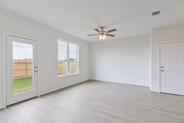 spare room with visible vents, baseboards, a ceiling fan, and light wood finished floors