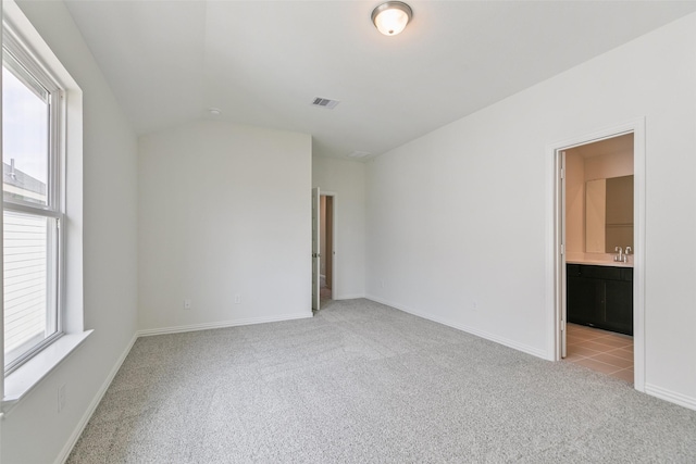 unfurnished room with light carpet, visible vents, a healthy amount of sunlight, and a sink