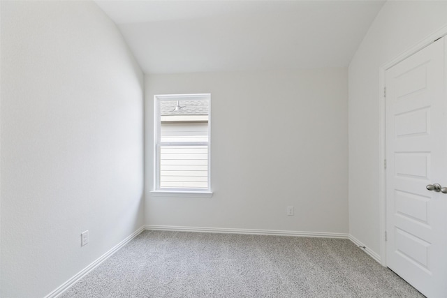 spare room featuring baseboards, light colored carpet, and lofted ceiling