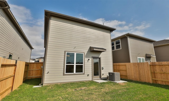 back of property featuring a lawn, central AC unit, and a fenced backyard