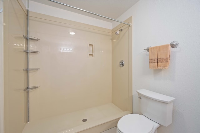 bathroom featuring toilet and walk in shower