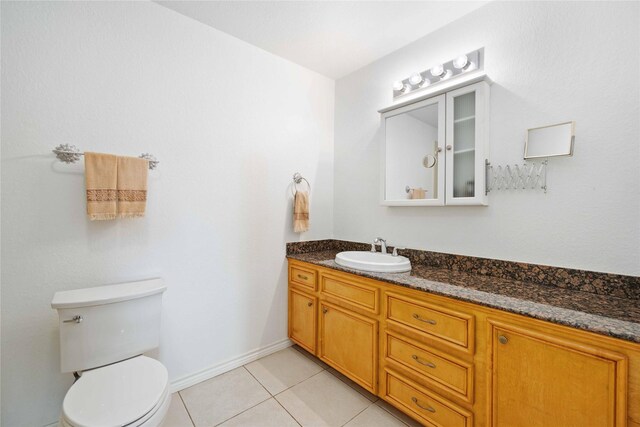 bathroom with toilet, tile patterned floors, and vanity