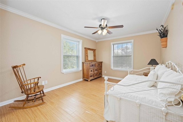 bedroom featuring ceiling fan, ornamental molding, hardwood / wood-style flooring, and multiple windows