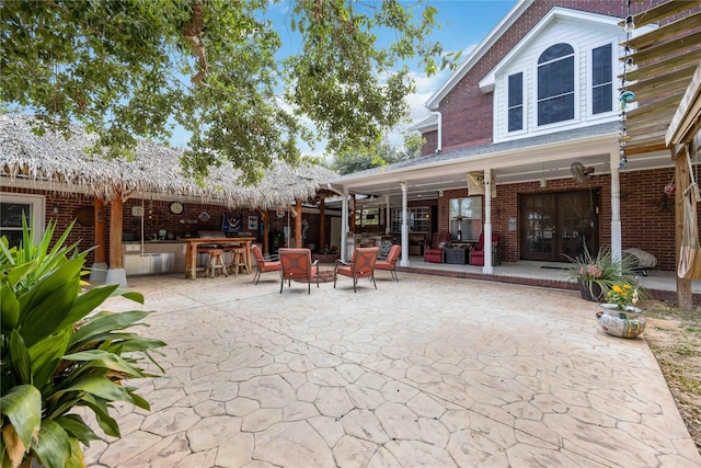 rear view of property with exterior bar and a patio area